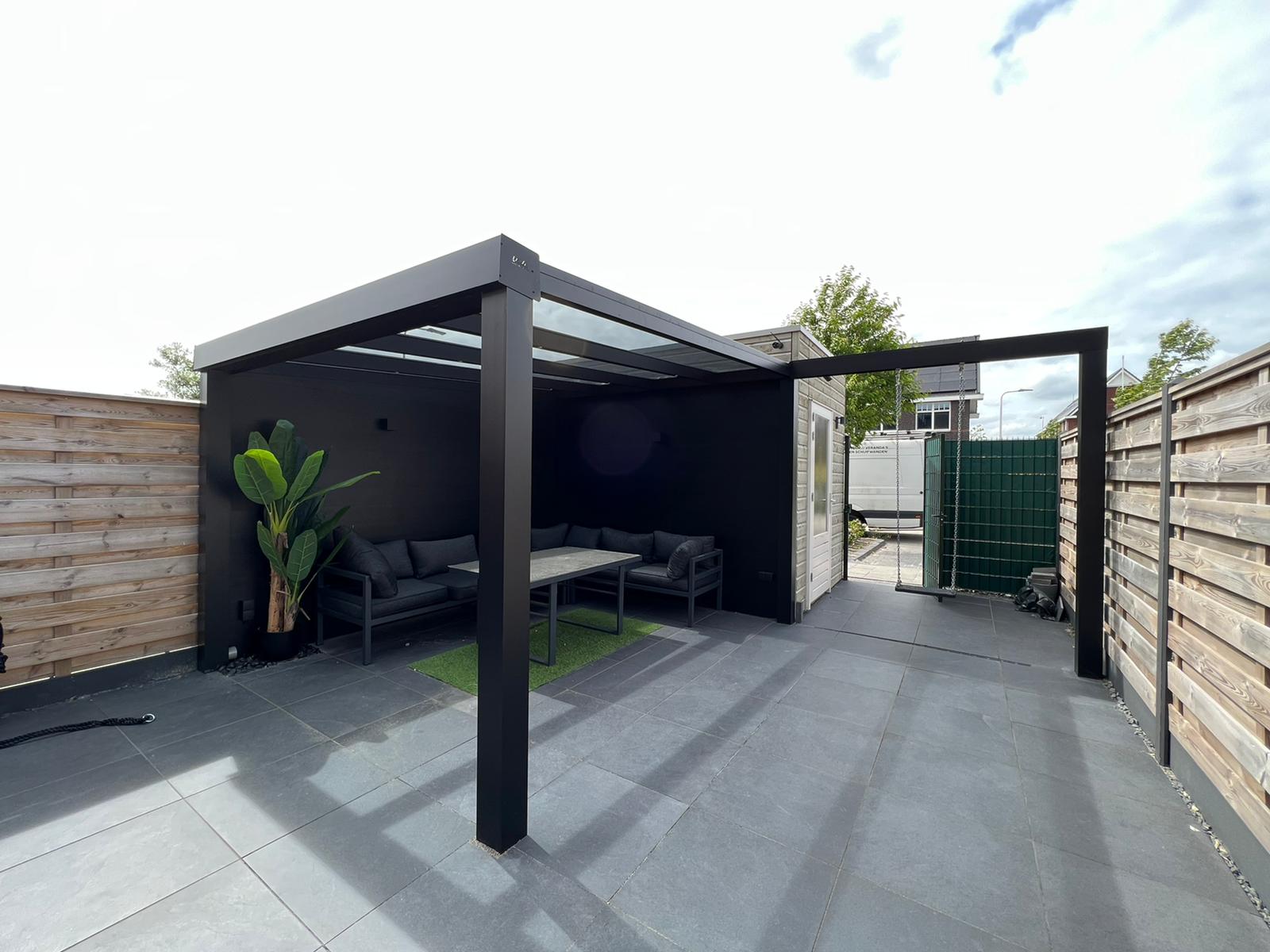 Kleine overkapping aan schuur. Overkapping tuin met schuur.